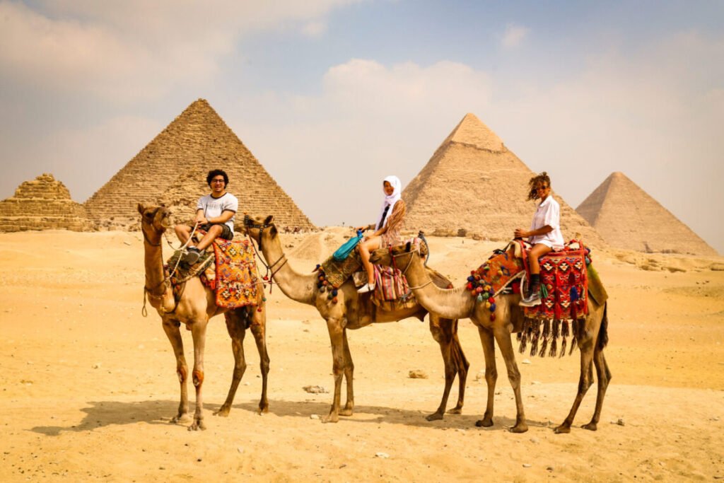 The Pyramids of Giza stand majestically against the Egyptian desert, showcasing ancient architectural marvels.
